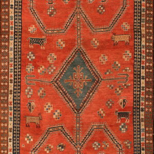 Terracotta rug featuring a dark blue central diamond, stylized animals, and complex multicolored borders.