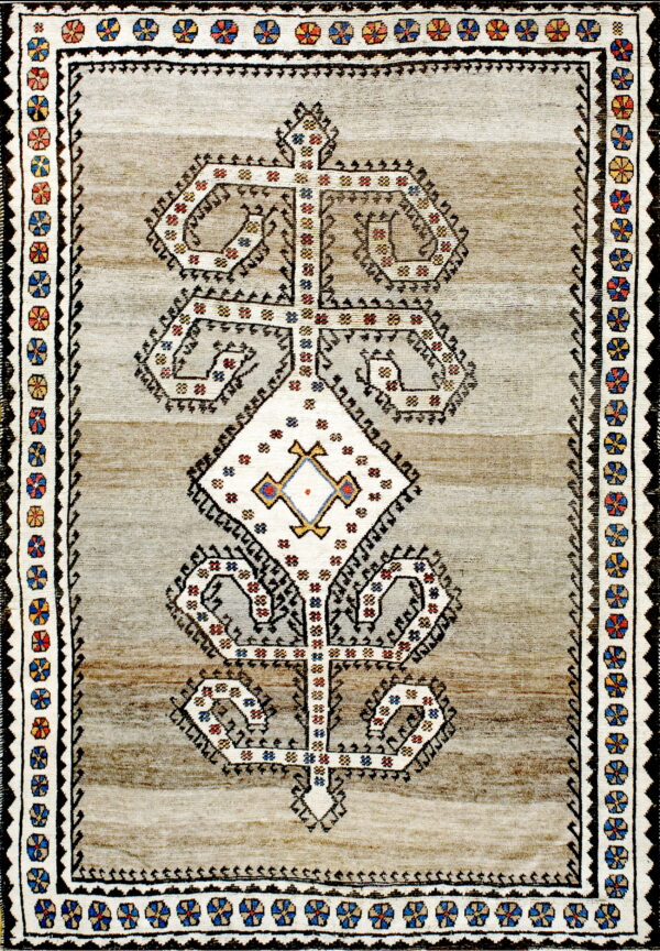 Striped beige and brown rug with a prominent white geometric totem motif and multicolored floral borders.