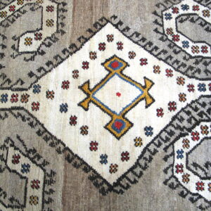 Gray rug detail showing a large off-white diamond with red, blue, and gold geometric accents.