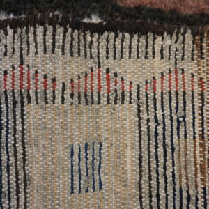 Close-up detail showing the high-pile surface meeting the flat-woven reverse side with multicolored dashed patterns.