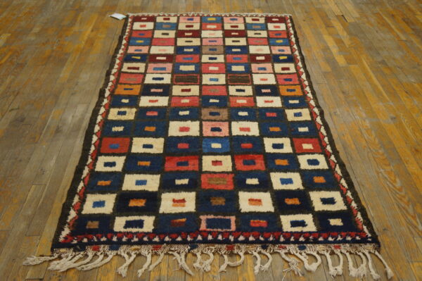 Runner rug with a high-pile, multicolored geometric square pattern on rustic wood floorboards.