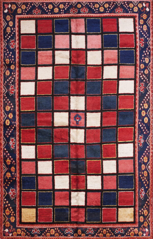 Area rug with a checkered design in red, navy, and cream, framed by a wide navy blue floral border.