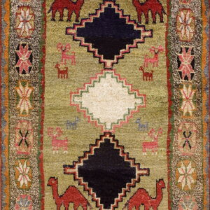 Textured green rug with red camel motifs and central black and white stepped diamonds.