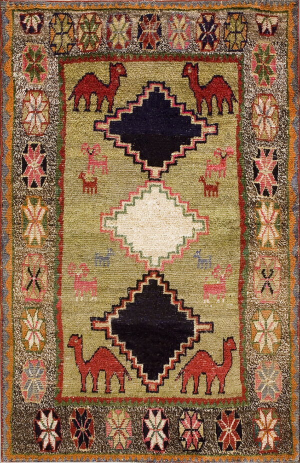Textured green rug with red camel motifs and central black and white stepped diamonds.