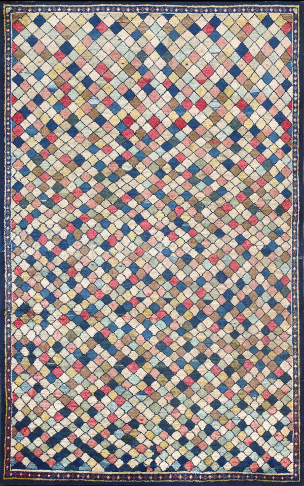 A polychromatic rug featuring a dense diamond lattice pattern framed by a wide, solid navy blue border.