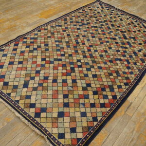 Multicolor checked diamond rug with a dark border lying on rustic, worn wood planks.