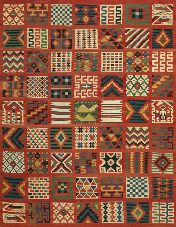 Multicolored flatweave rug with a red grid containing squares of diverse geometric and stylized patterns.