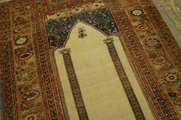 Floral rug featuring a light yellow arch field surrounded by detailed red, blue, and olive geometric borders.