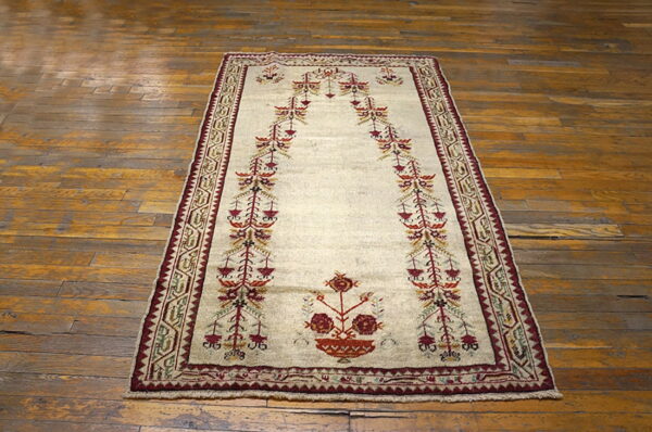 Beige rug featuring a detailed burgundy and orange stylized arch motif on distressed wood plank flooring.