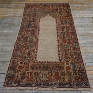 Red and tan low-pile runner rug featuring a central niche design on distressed gray wooden flooring.