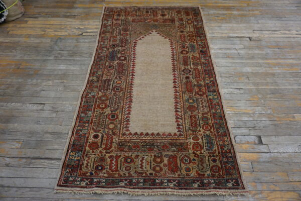 Red and tan low-pile runner rug featuring a central niche design on distressed gray wooden flooring.