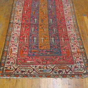 Geometric rug with colorful vertical panels in red, blue, orange, and cream on wood flooring.