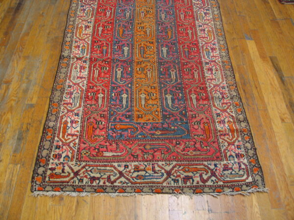 Geometric rug with colorful vertical panels in red, blue, orange, and cream on wood flooring.