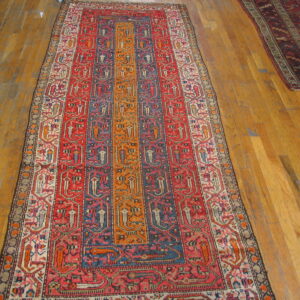 Red, blue, and orange striped geometric runner rug displayed on honey-toned hardwood planks.