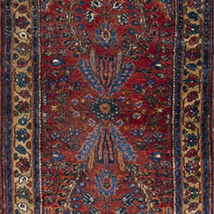 Low-pile runner with a dense red and blue traditional pattern and broad tan and navy borders.