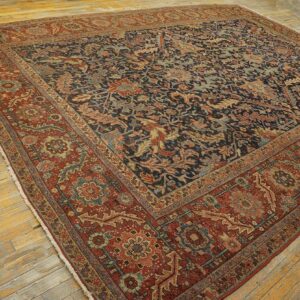 Detailed, dark blue and rust rug with an elaborate border rests on aged wood planks.