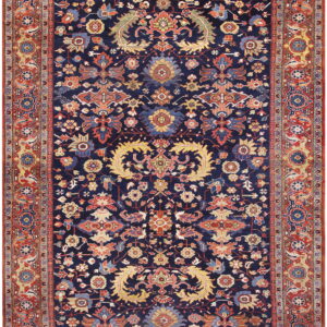 A traditional rug featuring a navy blue field with detailed red, gold, and blue floral and vine patterns.