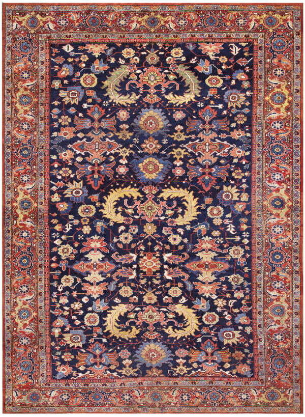 A traditional rug featuring a navy blue field with detailed red, gold, and blue floral and vine patterns.