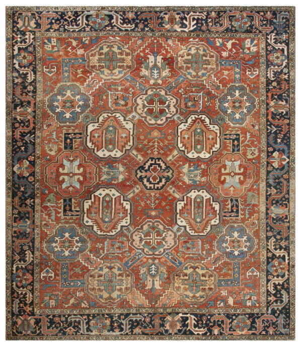 Traditional rug featuring a brick red field with blue and beige geometric medallions and a complex dark navy border.