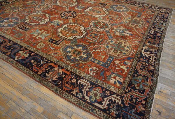 Rust and navy low-pile rug with geometric medallions rests on distressed wood planks.