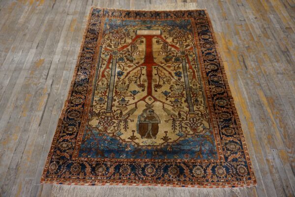Navy, beige, and red rug featuring an intricate tree and seated figure motif on distressed gray planks.