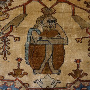 Stylized bearded figure woven into a tan rug field surrounded by red, blue, and brown floral motifs.