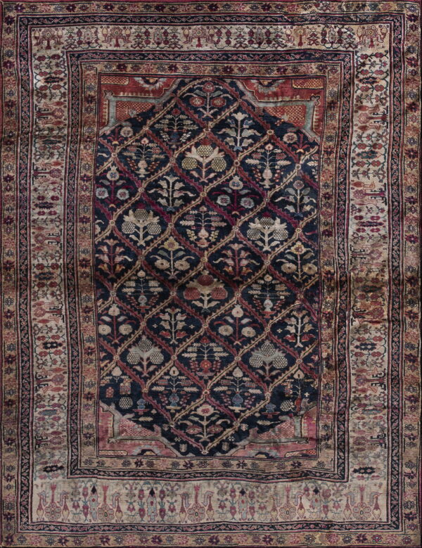 Dark blue rug with a central floral lattice and wide, complex borders in red, tan, and navy.