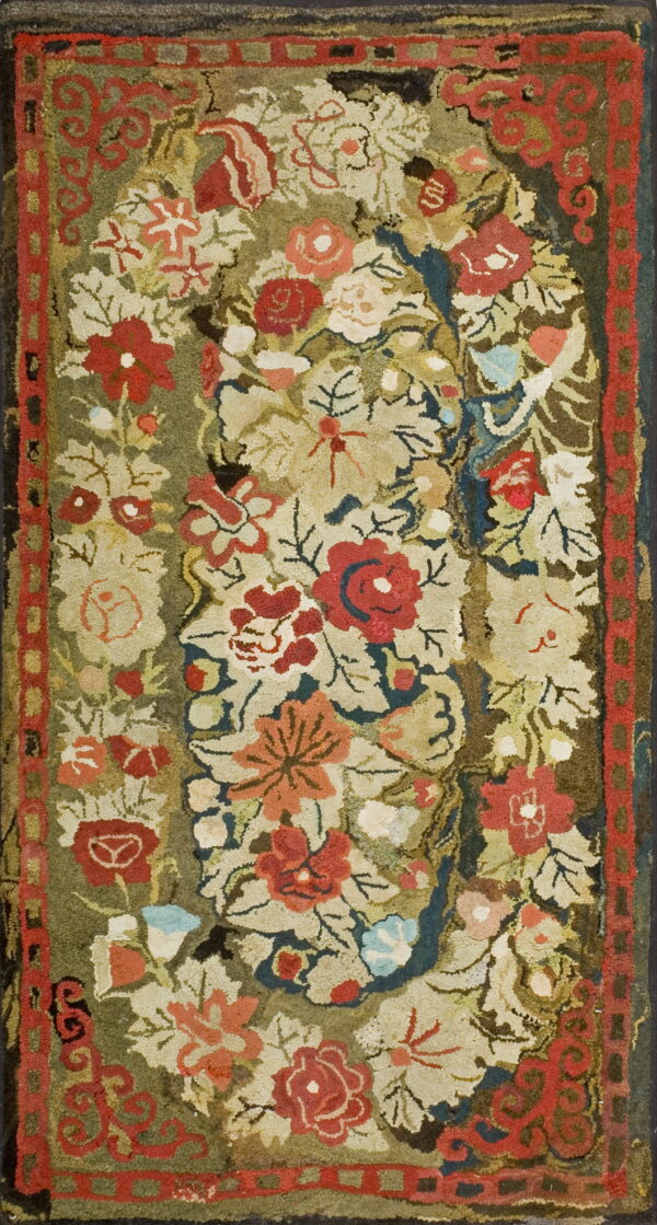 High-pile rug featuring a dense floral pattern in red, cream, and green with a geometric red border.