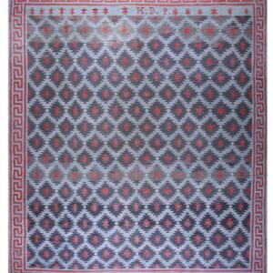 Flat-weave rug with blue and indigo geometric patterns, red accents, a Greek key border, and the letters K. D. P.