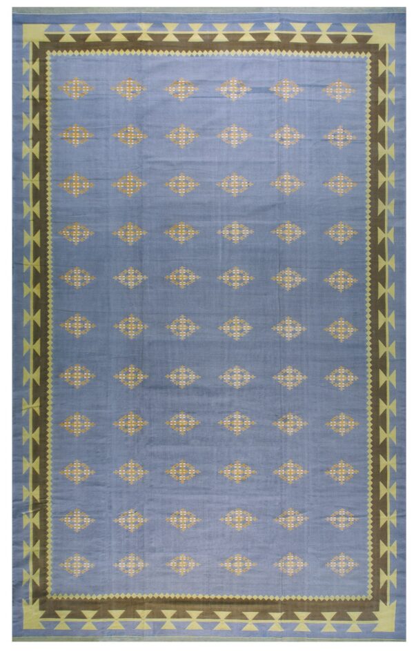 Light blue rug featuring repeated yellow geometric diamonds and a wide brown and lime-green patterned border.