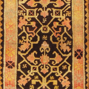 High-pile rug featuring a black ground with dense yellow and coral stylized floral and svastika motifs.