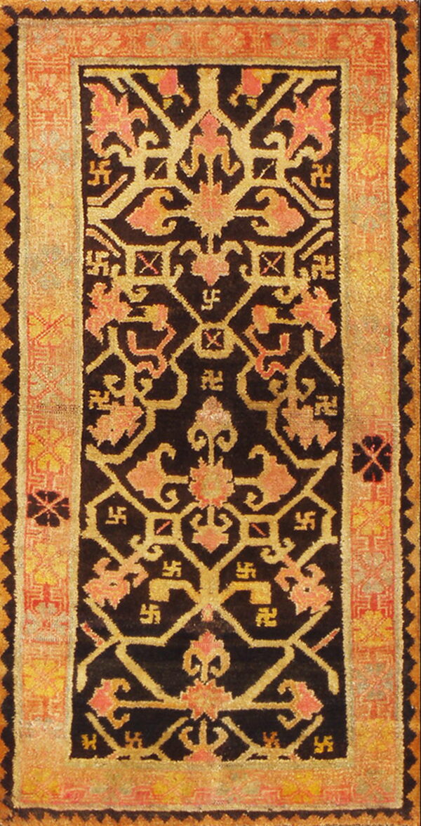 High-pile rug featuring a black ground with dense yellow and coral stylized floral and svastika motifs.