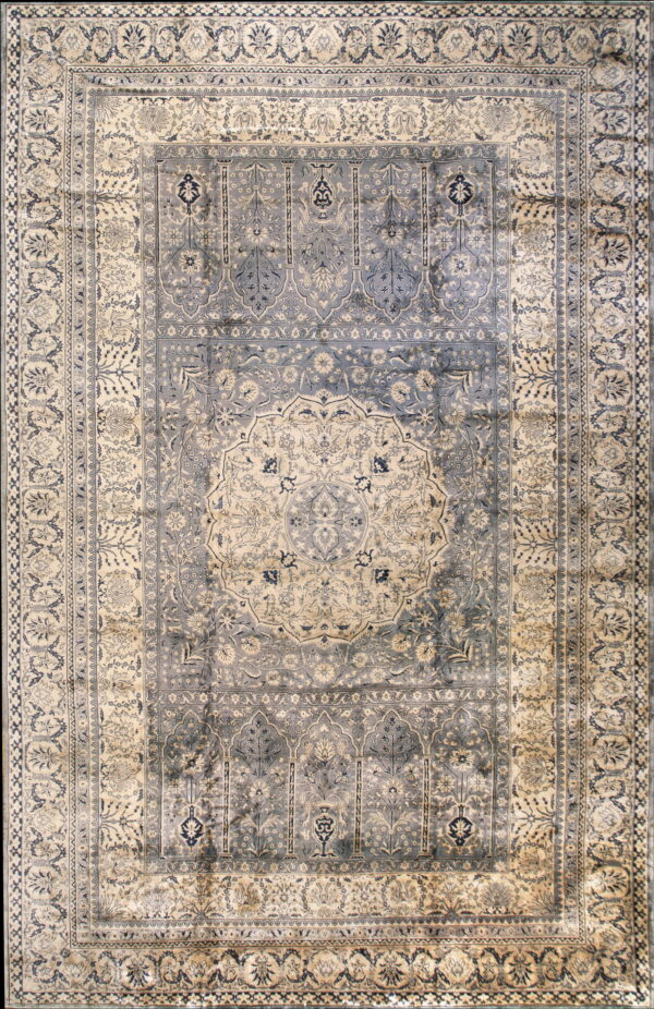 Distressed blue and cream traditional rug featuring a detailed central medallion and floral arch motifs.