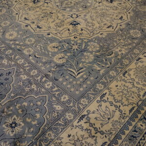 Ornate traditional rug in soft blue and cream colors, featuring a dense floral medallion and borders.
