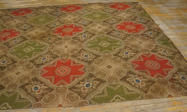 Low-pile rug with alternating red and olive medallions over a detailed brown pattern on distressed wood planks.