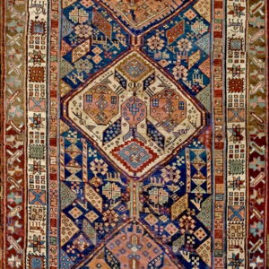Full view of a runner showing repeating rust and cream geometric medallions on a dark blue ground.