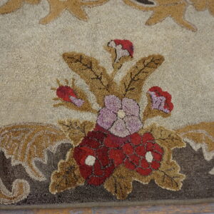The high-pile rug has a bouquet design of red and lavender flowers framed by brown scrolling leaves.