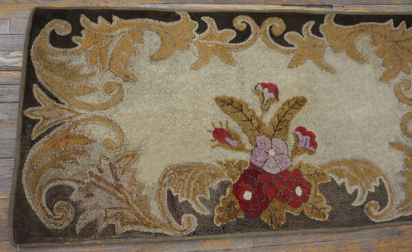 Ornate high-low pile rug featuring gold scrollwork, a beige center, and red-and-purple floral accents on wood flooring.