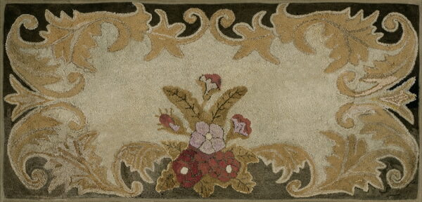 Beige hooked rug with a central red and mauve floral arrangement and scrolling gold leaf borders.
