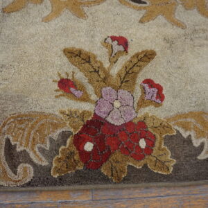High-pile rug featuring red and purple floral patterns with tan leaves on a cream background over wood flooring.