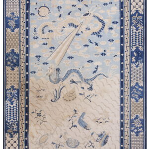 Blue and cream rug depicting a dragon rising from waves into a sky filled with clouds.