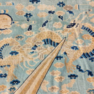 Light blue rug detail featuring a golden dragon design surrounded by cream, gray, and dark blue clouds.