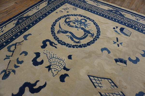 Beige rug featuring a detailed blue dragon medallion, scattered symbols, and geometric borders on wood flooring.