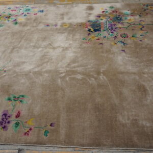 Low-pile beige rug with bright pink, purple, and green floral motifs on a distressed wood floor.