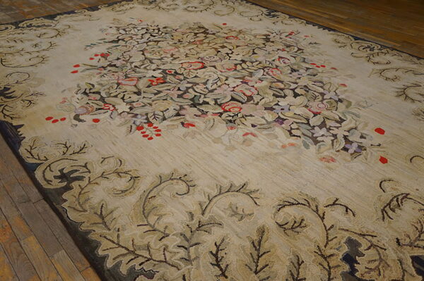 A large beige rug featuring a dense floral central design and scrolled borders rests on wood flooring.