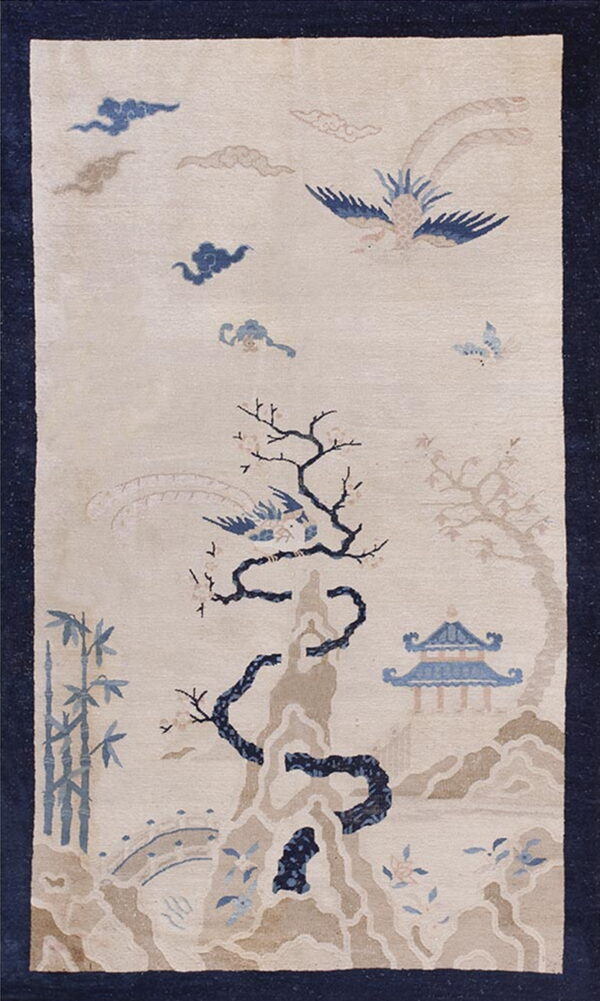 Cream rug with a navy border, featuring a blue and taupe pattern of a bird, trees, and pagoda.