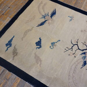 Low-pile beige rug featuring blue birds, taupe clouds, and a dark border, set against wood planks.