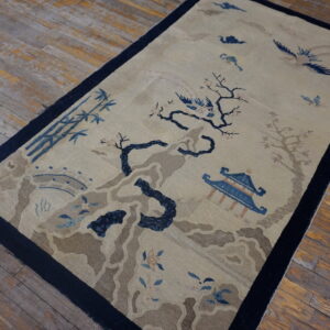 Beige rug with navy border and blue scenic pattern of trees, birds, and a pavilion on rustic wood floors.