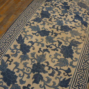 Low-pile runner featuring blue floral motifs and a key pattern border rests on rustic wood planks.
