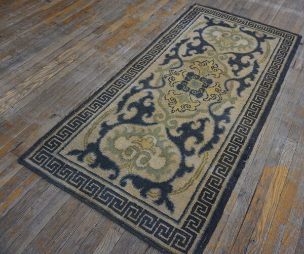 Beige runner rug featuring dark blue, green, and yellow ornate patterns on weathered wood planks.